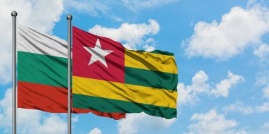 Bulgaristan ve Togo bayrağı birlikte beyaz bulutlu mavi gökyüzüne karşı rüzgarda sallayarak. Diplomasi kavramı, uluslararası ilişkiler.