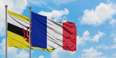 Brunei ve Reunion bayrağı birlikte beyaz bulutlu mavi gökyüzüne karşı rüzgarda sallayarak. Diplomasi kavramı, uluslararası ilişkiler.