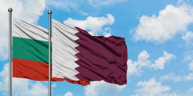 Bulgaristan ve Katar bayrağı birlikte beyaz bulutlu mavi gökyüzüne karşı rüzgarsal sallayarak. Diplomasi kavramı, uluslararası ilişkiler.