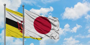 Brunei ve Japonya bayrağı birlikte beyaz bulutlu mavi gökyüzüne karşı rüzgarda sallayarak. Diplomasi kavramı, uluslararası ilişkiler.