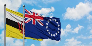 Brunei ve Cook Adaları bayrak birlikte beyaz bulutlu mavi gökyüzüne karşı rüzgarda sallayarak. Diplomasi kavramı, uluslararası ilişkiler.