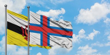 Brunei ve Faroe Adaları bayrağı birlikte beyaz bulutlu mavi gökyüzüne karşı rüzgarda sallayarak. Diplomasi kavramı, uluslararası ilişkiler.