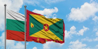Bulgaristan ve Grenada bayrağı birlikte beyaz bulutlu mavi gökyüzüne karşı rüzgarda sallayarak. Diplomasi kavramı, uluslararası ilişkiler.