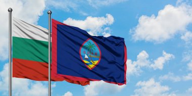 Bulgaristan ve Guam bayrağı birlikte beyaz bulutlu mavi gökyüzüne karşı rüzgarda sallayarak. Diplomasi kavramı, uluslararası ilişkiler.