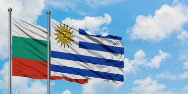 Bulgaristan ve Uruguay bayrağı birlikte beyaz bulutlu mavi gökyüzüne karşı rüzgarsal sallayarak. Diplomasi kavramı, uluslararası ilişkiler.