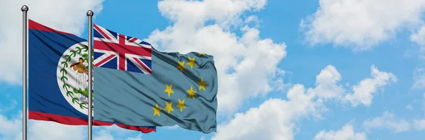 Bandera de Belice y Tuvalu ondeando en el viento contra el cielo azul nublado blanco juntos. Concepto diplomático, relaciones internacionales . — Foto de Stock