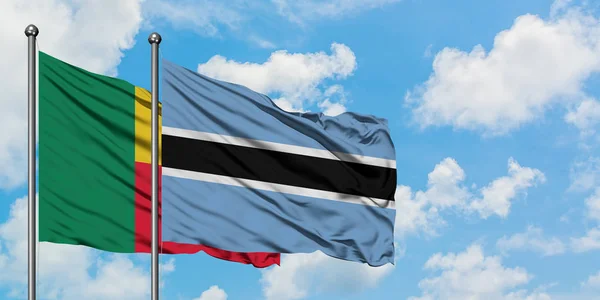 Benin e Botswana sventolano insieme la bandiera contro il bianco cielo azzurro nuvoloso. Concetto di diplomazia, relazioni internazionali . — Foto Stock