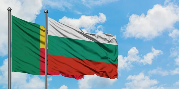 Bandera de Benín y Bulgaria ondeando en el viento contra el cielo azul nublado blanco juntos. Concepto diplomático, relaciones internacionales . — Foto de Stock