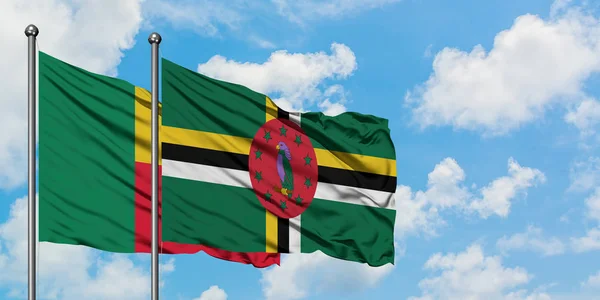 Bandera de Benín y Dominica ondeando en el viento contra el cielo azul nublado blanco juntos. Concepto diplomático, relaciones internacionales . — Foto de Stock