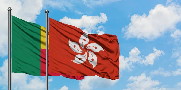 Bandera de Benin y Hong Kong ondeando en el viento contra el cielo azul nublado blanco juntos. Concepto diplomático, relaciones internacionales . — Foto de Stock