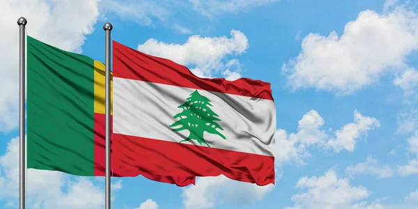Bandera de Benín y Líbano ondeando en el viento contra el cielo azul nublado blanco juntos. Concepto diplomático, relaciones internacionales . — Foto de Stock