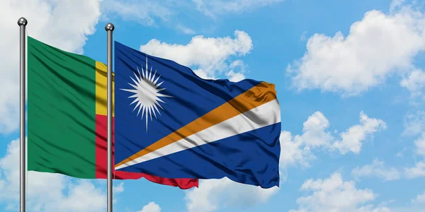 Benin und Marshall Islands Flagge wehen gemeinsam im Wind vor weißem wolkenlosem blauen Himmel. Diplomatie-Konzept, internationale Beziehungen. — Stockfoto