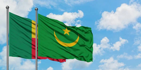 Bandera de Benín y Mauritania ondeando en el viento contra el cielo azul nublado blanco juntos. Concepto diplomático, relaciones internacionales . — Foto de Stock