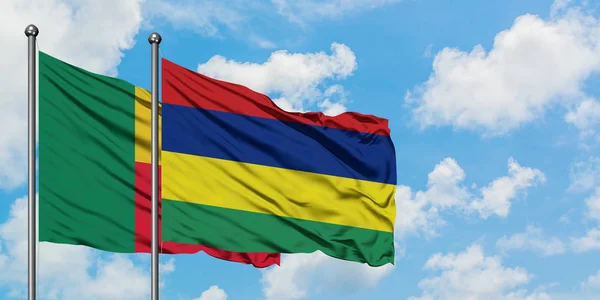 Bandera de Benín y Mauricio ondeando en el viento contra el cielo azul nublado blanco juntos. Concepto diplomático, relaciones internacionales . — Foto de Stock