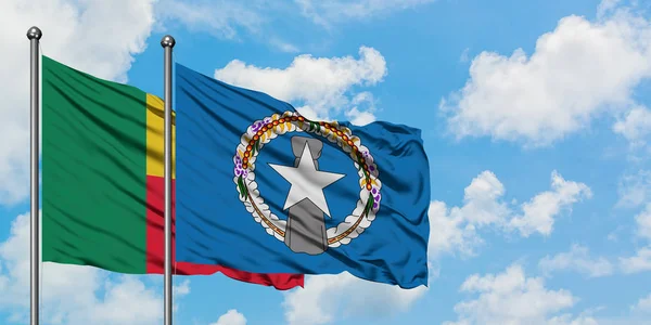 Bandera de Benín y las Islas Marianas del Norte ondeando en el viento contra el cielo azul nublado blanco juntos. Concepto diplomático, relaciones internacionales . — Foto de Stock