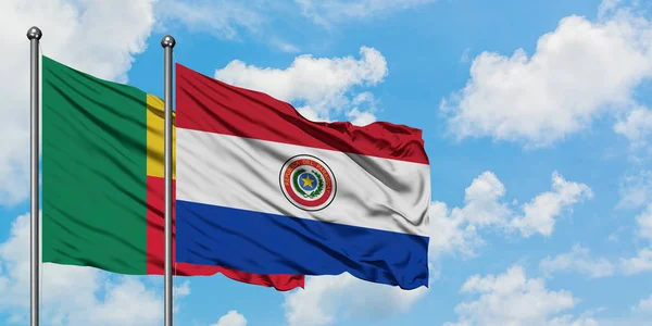 Bandera de Benín y Paraguay ondeando en el viento contra el cielo azul nublado blanco juntos. Concepto diplomático, relaciones internacionales . — Foto de Stock