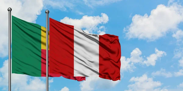 Bandera de Benín y Perú ondeando en el viento contra el cielo azul nublado blanco juntos. Concepto diplomático, relaciones internacionales . — Foto de Stock