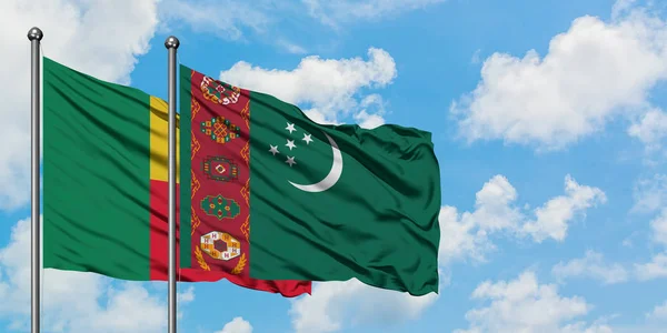 Benin a Turkmenistán vlají ve větru proti bíle zatažené modré obloze. Diplomacie, mezinárodní vztahy. — Stock fotografie