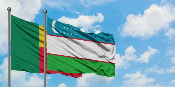 Bandera de Benín y Uzbekistán ondeando en el viento contra el cielo azul nublado blanco juntos. Concepto diplomático, relaciones internacionales . —  Fotos de Stock