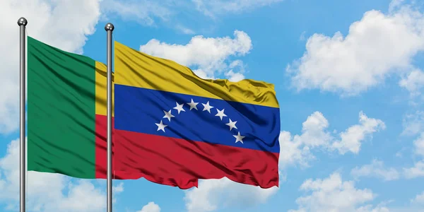 Η σημαία του Μπενίν και της Βενεζουέλας κουνώντας τον άνεμο εναντίον του λευκού νεφελού γαλάζιου ουρανού μαζί. Φιλοσοφία της διπλωματίας, διεθνείς σχέσεις. — Φωτογραφία Αρχείου