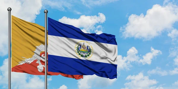 Bandera de Bután y El Salvador ondeando en el viento contra el cielo azul nublado blanco juntos. Concepto diplomático, relaciones internacionales . — Foto de Stock