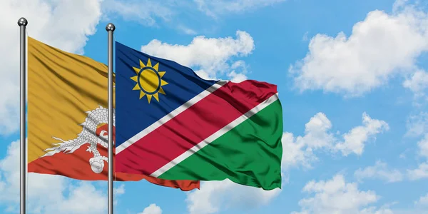 Bhutan and Namibia flag waving in the wind against white cloudy blue sky together. Diplomacy concept, international relations. — Stock Photo, Image