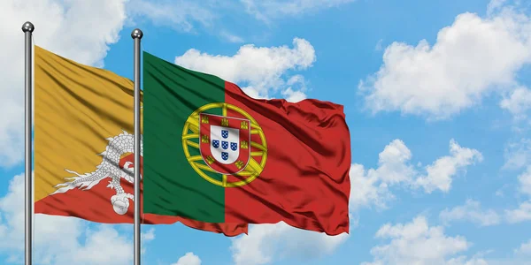 Bandera de Bután y Portugal ondeando en el viento contra el cielo azul nublado blanco juntos. Concepto diplomático, relaciones internacionales . — Foto de Stock