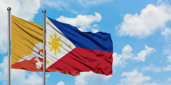 不丹和菲律宾国旗在风中飘扬，白云蓝天相聚。外交概念、国际关系. — 图库照片