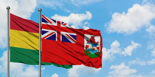 Bandera de Bolivia y Bermudas ondeando en el viento contra el cielo azul nublado blanco juntos. Concepto diplomático, relaciones internacionales . — Foto de Stock