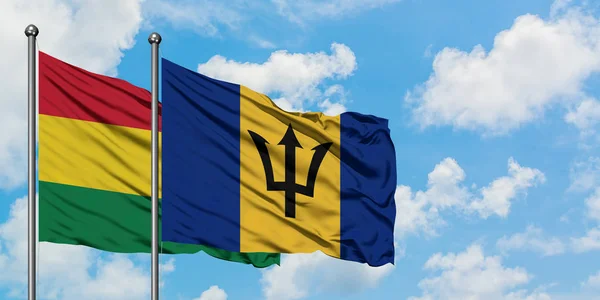 Bolivia and Barbados flag waving in the wind against white cloudy blue sky together. Diplomacy concept, international relations. — Stock Photo, Image