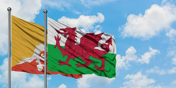 Bhutan en Wales vlag zwaaien in de wind tegen witte bewolkte blauwe hemel samen. Diplomatie concept, internationale betrekkingen. — Stockfoto