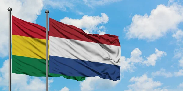 玻利维亚和荷兰国旗在风中飘扬，白云蓝天相聚。外交概念、国际关系. — 图库照片