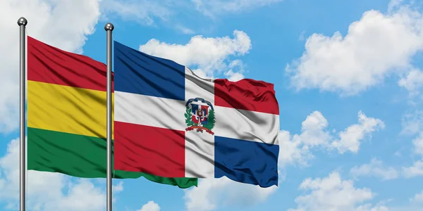 Болівія і Домініканська Республіка прапор розмахуючи на вітрі від білого хмарного синього неба разом. Концепція дипломатії, міжнародні відносини. — стокове фото