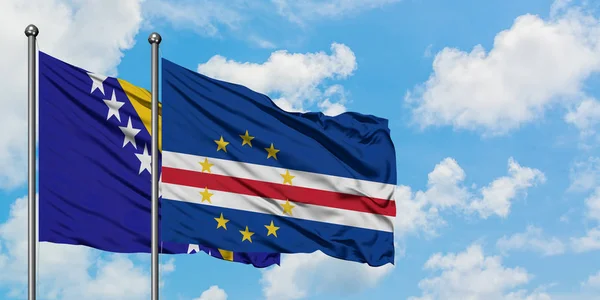 Bandera de Bosnia Herzegovina y Cabo Verde ondeando en el viento contra el cielo azul nublado blanco juntos. Concepto diplomático, relaciones internacionales . — Foto de Stock