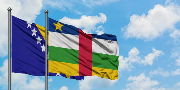 Bandera de Bosnia Herzegovina y República Centroafricana ondeando en el viento contra el cielo azul nublado blanco juntos. Concepto diplomático, relaciones internacionales . — Foto de Stock