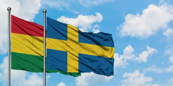 玻利维亚和瑞典国旗在风中飘扬，与白云蓝天相一起。外交概念、国际关系. — 图库照片