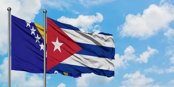 Vlajka Bosny a Hercegoviny a Kuby ve větru mávajících proti bílé zamračené modré obloze. Diplomacie, mezinárodní vztahy. — Stock fotografie