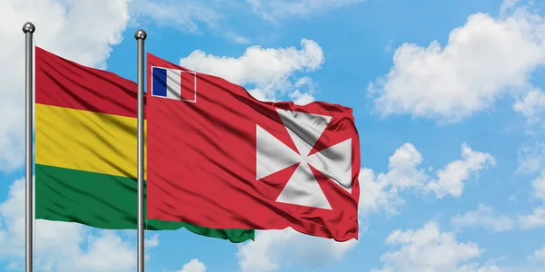 Bandera de Bolivia y Wallis y Futuna ondeando en el viento contra el cielo azul nublado blanco juntos. Concepto diplomático, relaciones internacionales . — Foto de Stock
