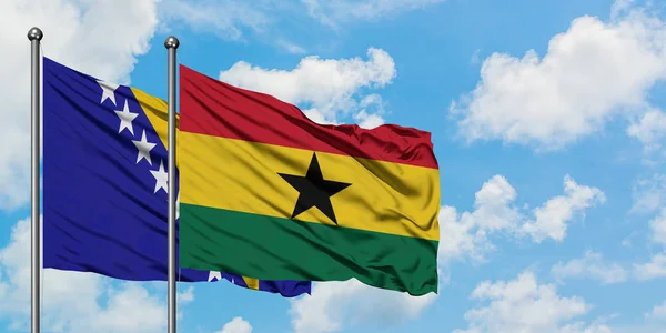 Bandera de Bosnia Herzegovina y Ghana ondeando en el viento contra el cielo azul nublado blanco juntos. Concepto diplomático, relaciones internacionales . — Foto de Stock