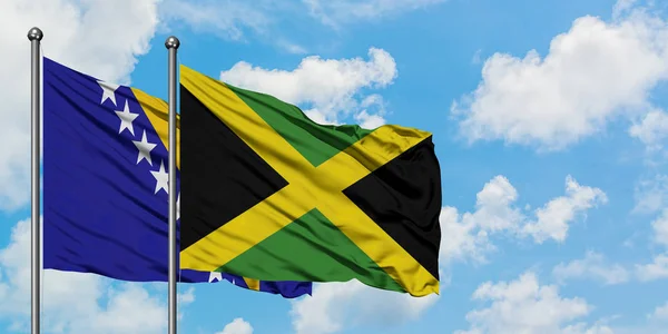 Bosnia Herzegovina and Jamaica flag waving in the wind against white cloudy blue sky together. Diplomacy concept, international relations. — Stock Photo, Image