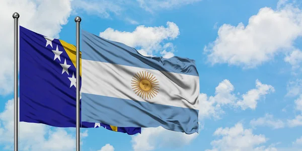 보스니아 헤르체고비나와 아르헨티나 국기가 하얀 흐린 푸른 하늘을 배경으로 바람에 흔들리고 있습니다. 외교 개념, 국제 관계. — 스톡 사진