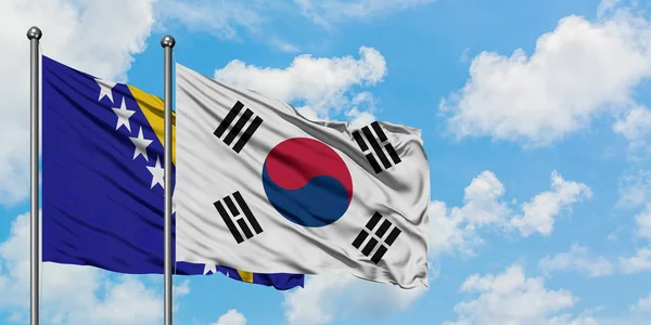 Bosnia Herzegovina and South Korea flag waving in the wind against white cloudy blue sky together. Diplomacy concept, international relations. — Stock Photo, Image