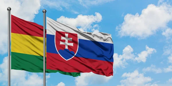 Drapeau de la Bolivie et de la Slovaquie agitant dans le vent contre ciel bleu nuageux blanc ensemble. Concept de diplomatie, relations internationales . — Photo