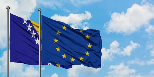 A Bósnia-Herzegovina e a União Europeia acenam com o vento contra o céu azul nublado branco juntos. Conceito de diplomacia, relações internacionais . — Fotografia de Stock
