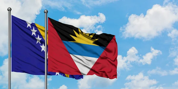 Bosna Hersek ve Antigua ve Barbuda bayrağı birlikte beyaz bulutlu mavi gökyüzüne karşı rüzgarda sallayarak. Diplomasi kavramı, uluslararası ilişkiler. — Stok fotoğraf