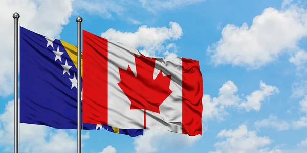 Bandera de Bosnia Herzegovina y Canadá ondeando en el viento contra el cielo azul nublado blanco juntos. Concepto diplomático, relaciones internacionales . — Foto de Stock