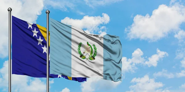 Bosnia Herzegovina and Guatemala flag waving in the wind against white cloudy blue sky together. Diplomacy concept, international relations. — Stock Photo, Image