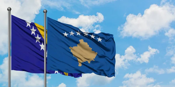 Η σημαία της Βοσνίας Ερζεγοβίνης και του Κοσσυφοπεδίου χαιρετά τον άνεμο ενάντια στον λευκό συννεφιασμένο γαλάζιο ουρανό. Φιλοσοφία της διπλωματίας, διεθνείς σχέσεις. — Φωτογραφία Αρχείου