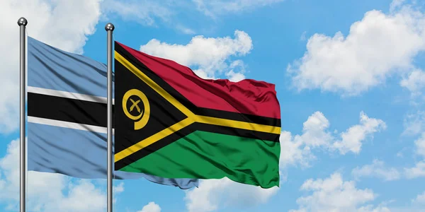 Bandera de Botswana y Vanuatu ondeando en el viento contra el cielo azul nublado blanco juntos. Concepto diplomático, relaciones internacionales . — Foto de Stock