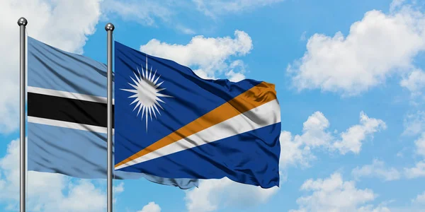 Botswana e Marshall Isole bandiera sventolando nel vento contro bianco cielo blu nuvoloso insieme. Concetto di diplomazia, relazioni internazionali . — Foto Stock